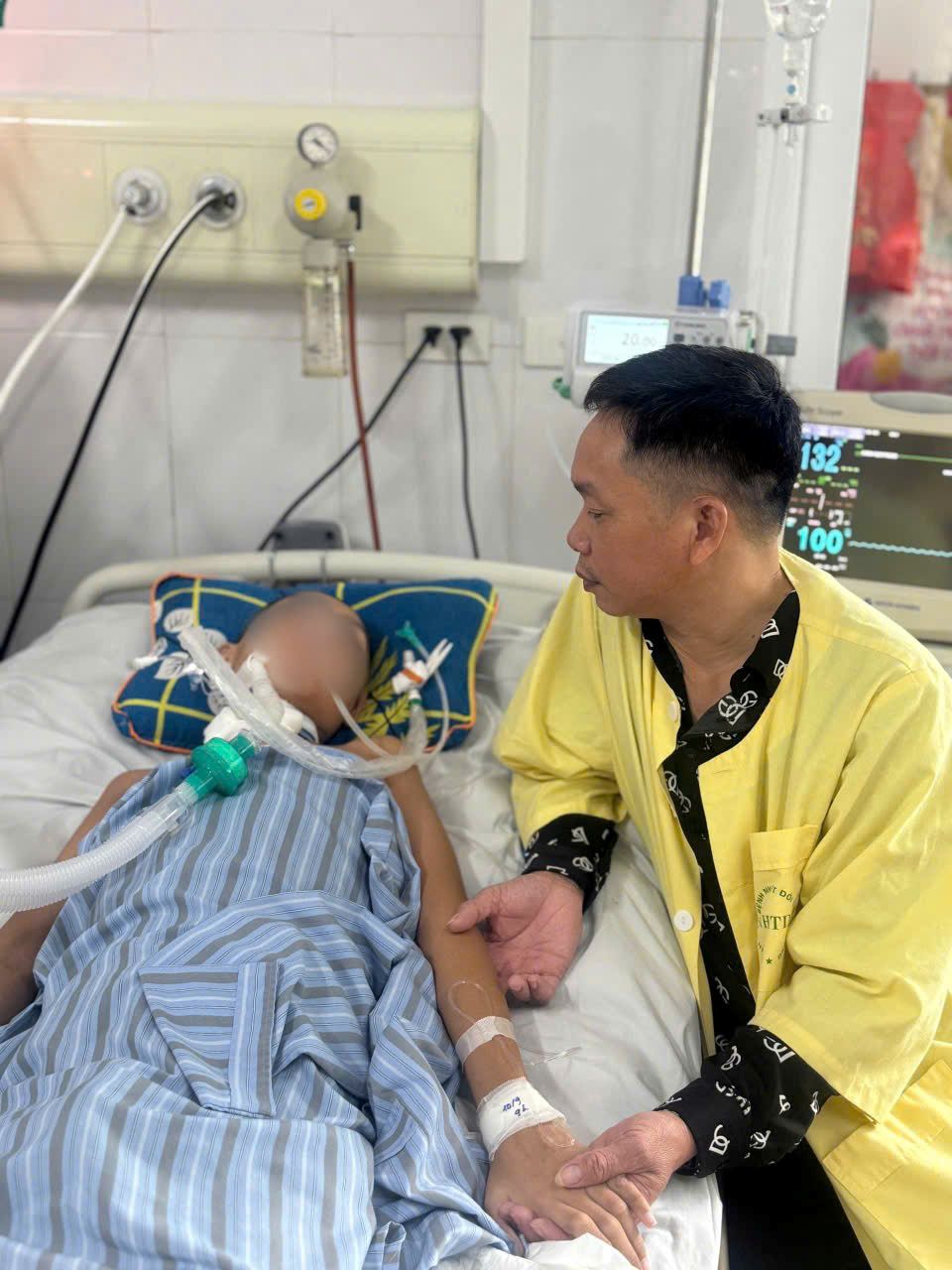 Anh Do Huu Nang (Hai Phong) dong vien con trai tren giuong benh. Ảnh: Gia dinh cung cap