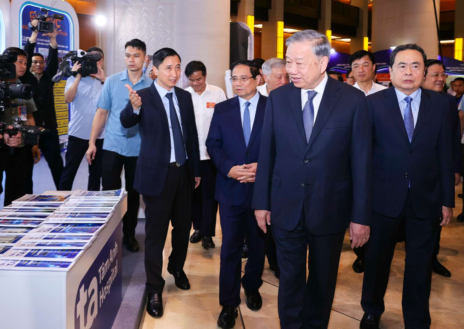 Ong Ngo Chi Dung, Chu tich Hoi dong Quan tri He thong Benh vien Da khoa Tam Anh gioi thieu voi Tong Bi thu To Lam va cac lanh dao cap cao cua Dang, Nha nuoc ve khu vuc trung bay cua He thong BVDK Tam Anh tai Trien lam. Anh: Nhat Bac