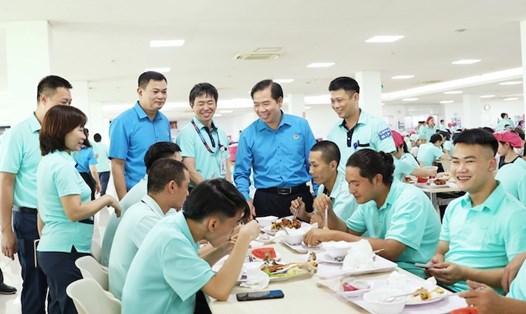 Phó Chủ tịch LĐLĐ Thành phố Hà Nội Nguyễn Huy Khánh (đứng thứ 2 từ phải sang) cùng tham gia Bữa cơm Công đoàn 2025 với người lao động. Ảnh: Kiều Vũ