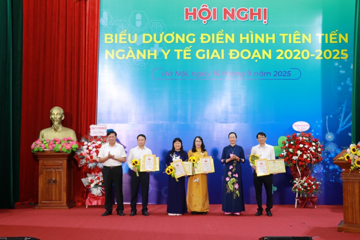 M. Do Xuan Tuyen - vice-ministre de la Sante et Mme Pham Thanh Binh - presidente du Syndicat vietnamien de la sante remettent des certificats de merite et des certificats a 4 collectifs exceptionnels dans les mouvements de competition. Photo : Xuan Bach