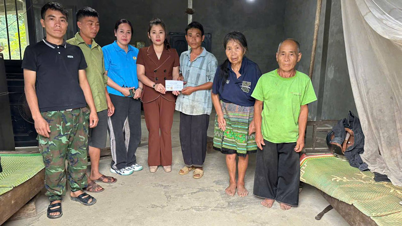 Mme Vuong Thi Anh - president du syndicat de Nghia Lo Ward, province de Lao Cai - a remis un soutien a sa famille de Thao A. Photo: Vuong Anh