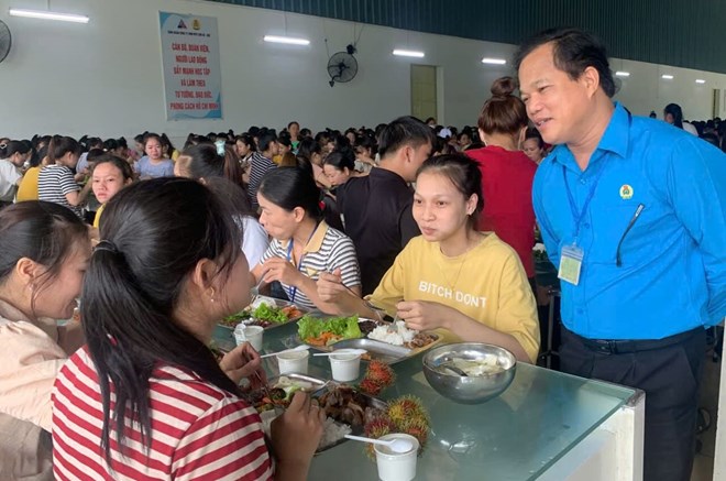 Le Minh Nhan 씨 - 후에시 노동 연맹 위원장이 Camera에서 노동자들에게 안부를 묻고 격려하고 있습니다. Camera 노동 조합의 따뜻한 식사. 사진: Nha Phuong