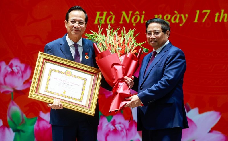 Prime Minister Pham Minh Chinh presented the 40-year Party membership badge and presented flowers to congratulate Minister Dao Ngoc Dung. Photo: Nhat Bac