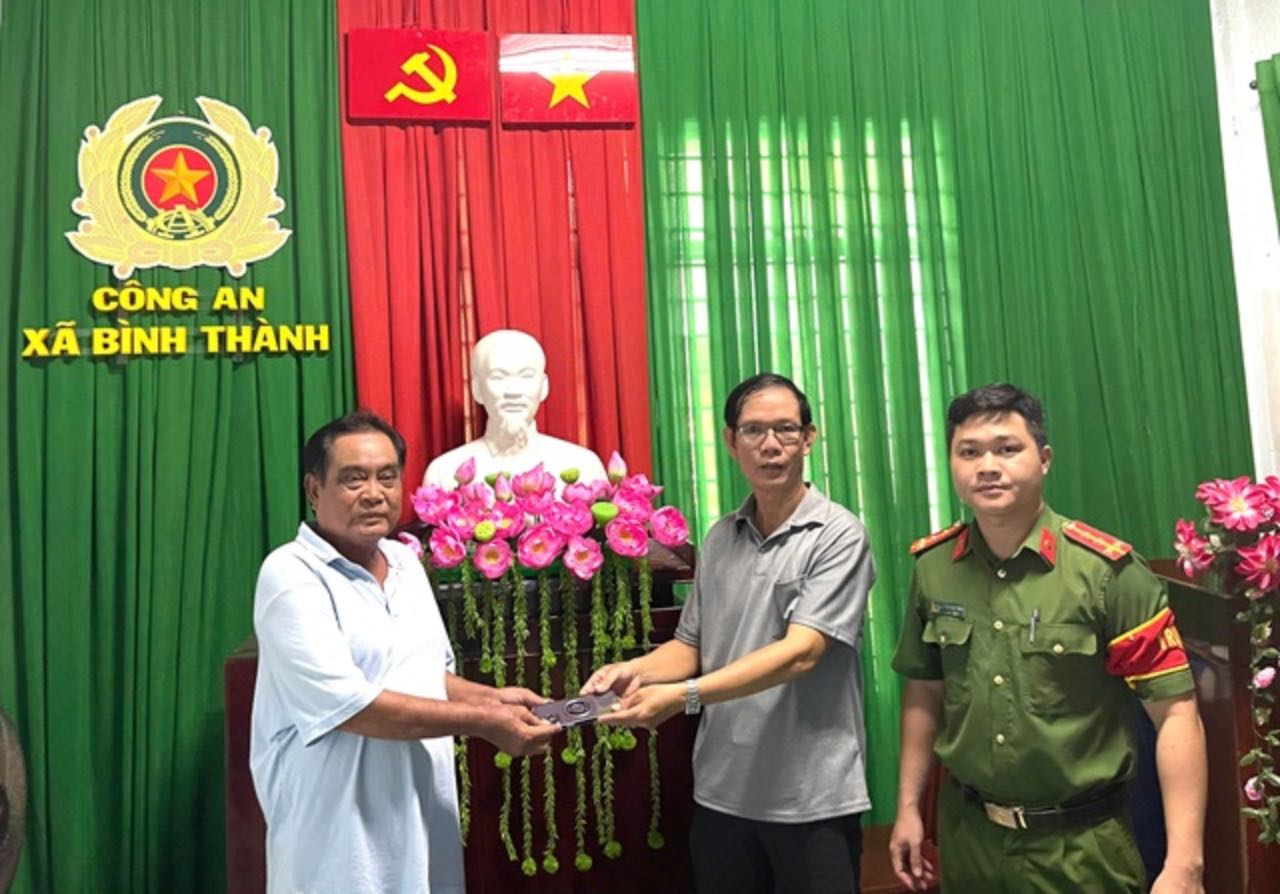 El Sr. Tai (segundo desde la derecha) entrega los bienes perdidos al Sr. Dung (izquierda). Foto: Policia Provincial de Dong Thap