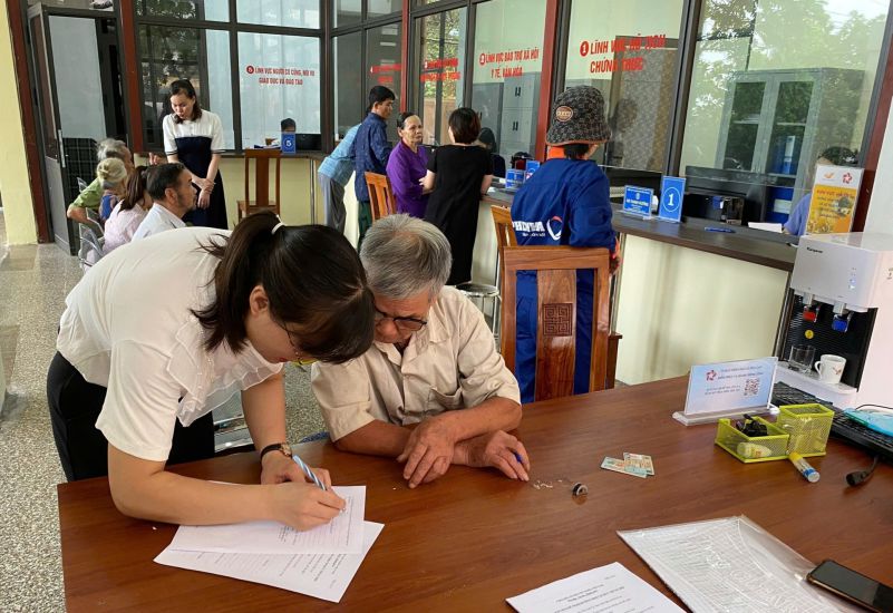 Cong chuc Trung tam Phuc vu hanh chinh cong xa Hoa Lac (Ha Noi) ho tro tan tinh nguoi dan giai quyet thu tuc giay to. Anh: Vu Van