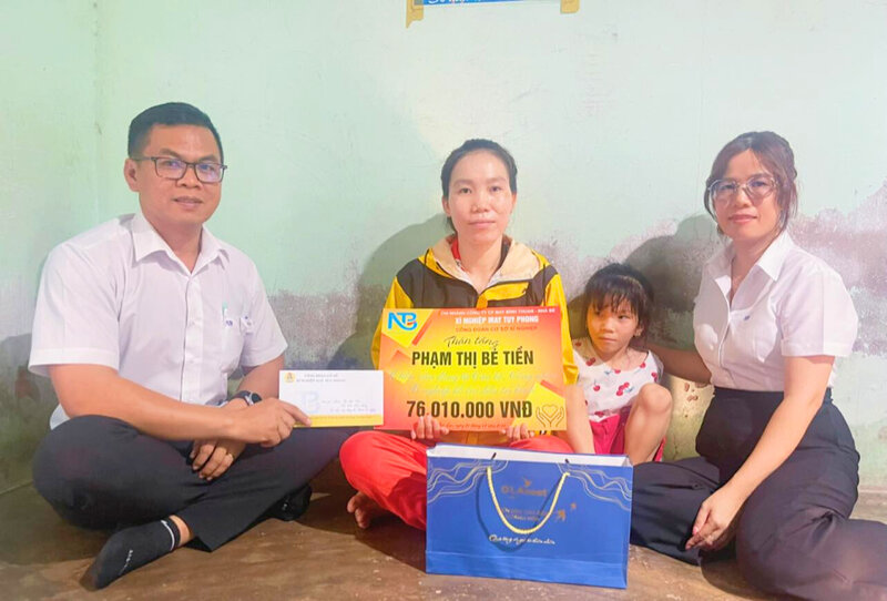 Chu tich Cong doan co so Xi nghiep May Tuy Phong - anh Nguyen Hoa (bia trai) trao ho tro chi Pham Thi Be Tien. Anh: Duc Lam