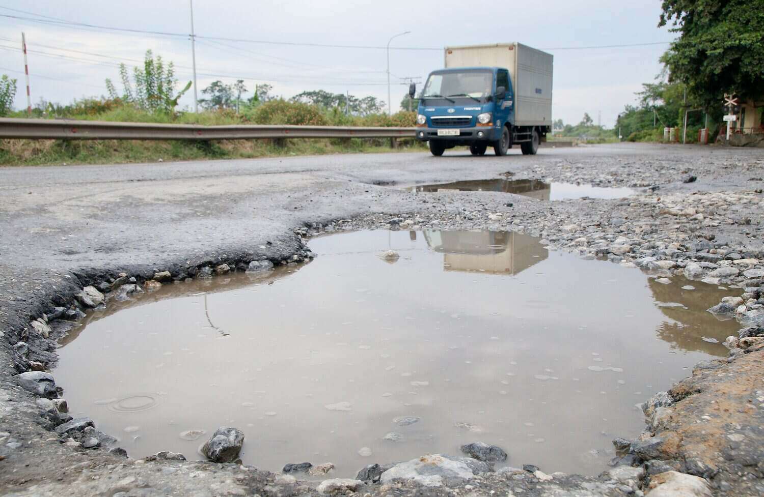 Les nids de poule et les nids d'elephants sur la route nationale 32C recelent un risque de perte de securite routiere. Photo : Quoc Dai