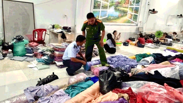 Lực lượng chức năng kiểm tra số hàng hoá vi phạm tại cơ sở kinh doanh. Ảnh: Lê Kha 