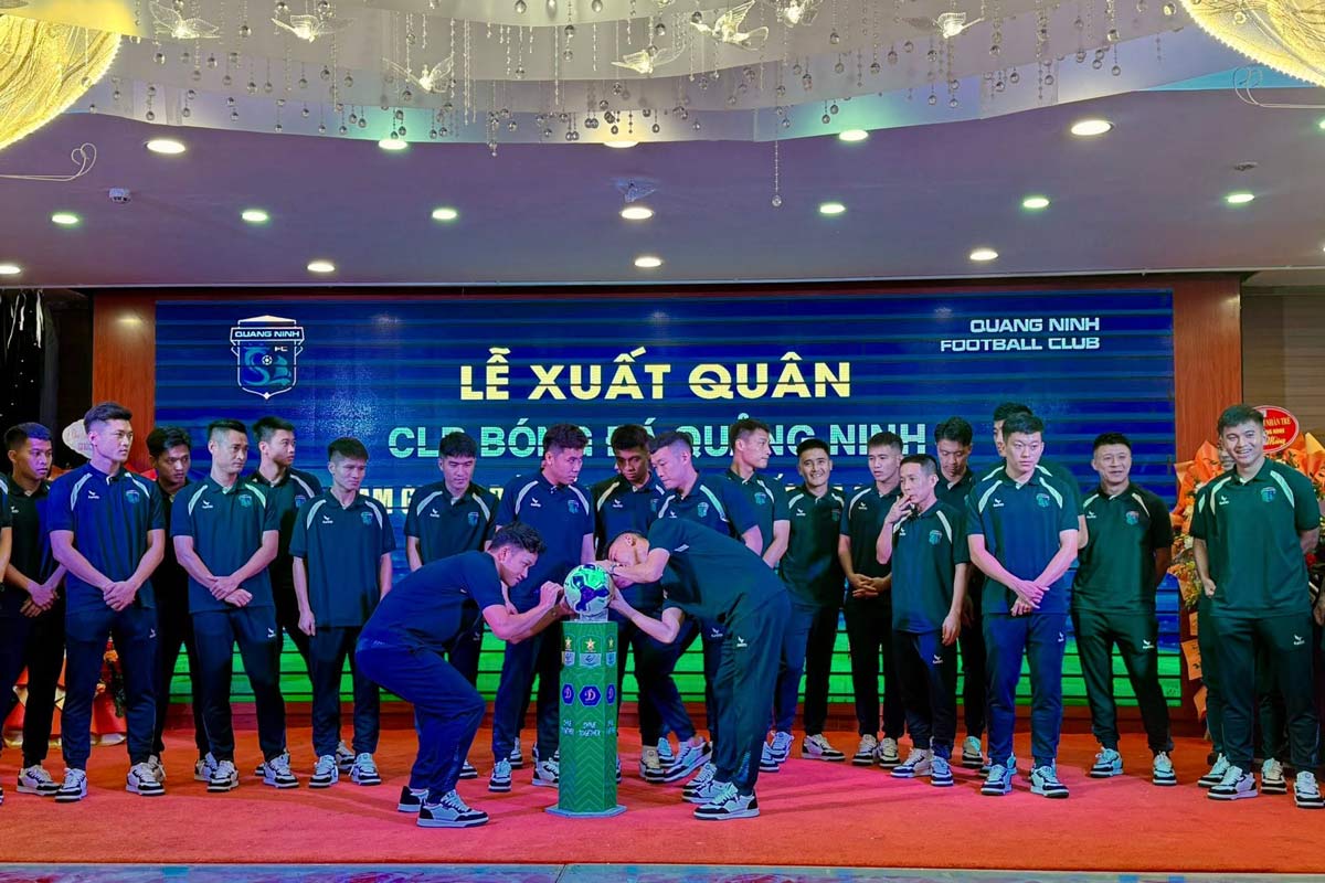 クアンニンサッカークラブの選手たちは記念ボールにサインし、勝利への決意を示しました。写真:Thanh Tung