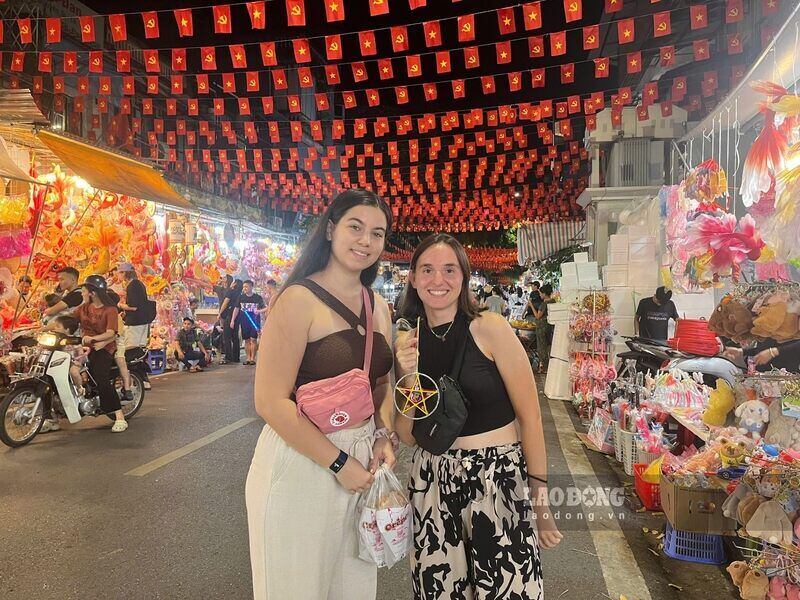 Hai du khach Phap an tuong khi dao quanh pho Hang Ma mua Trung thu. Ảnh: Tuong Vy