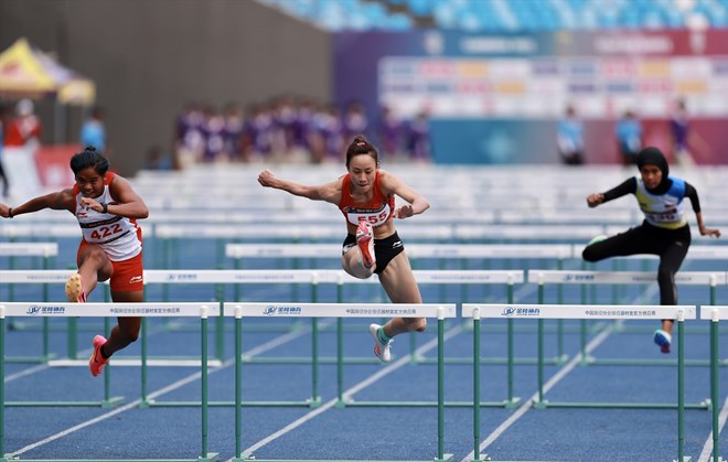 Athletes compete in the 100m event over the women's athletics bar at the 32nd SEA Games. Photo: Duy Nam