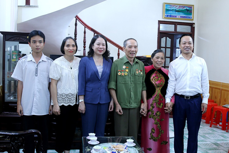 Pho Chu tich nuoc Vo Thi Anh Xuan va ong Tran Tien Dung - Pho Bi thu Tinh uy chup anh luu niem cung gia dinh thuong binh Nguyen Dinh Tam. Anh: UBND tinh Dien Bien