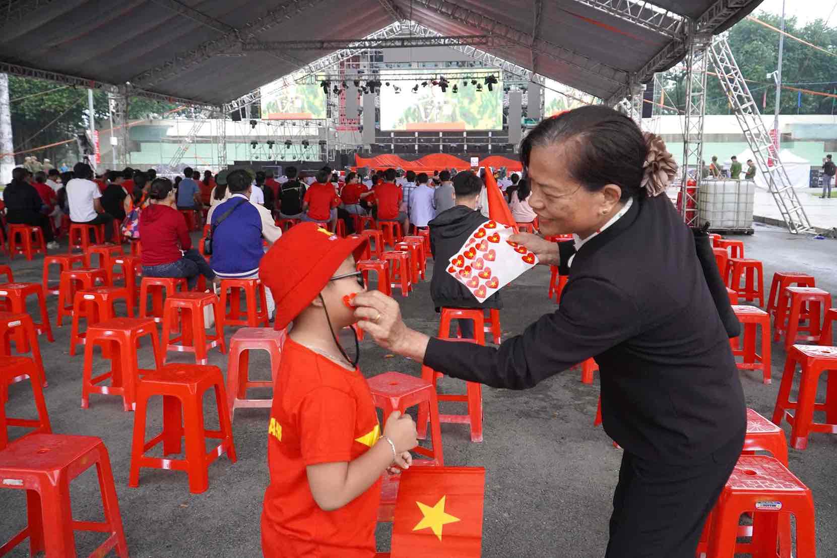 Co Nguyen Thi Bay dan co cho mot chau be la con cong nhan lao dong. Anh: HAC