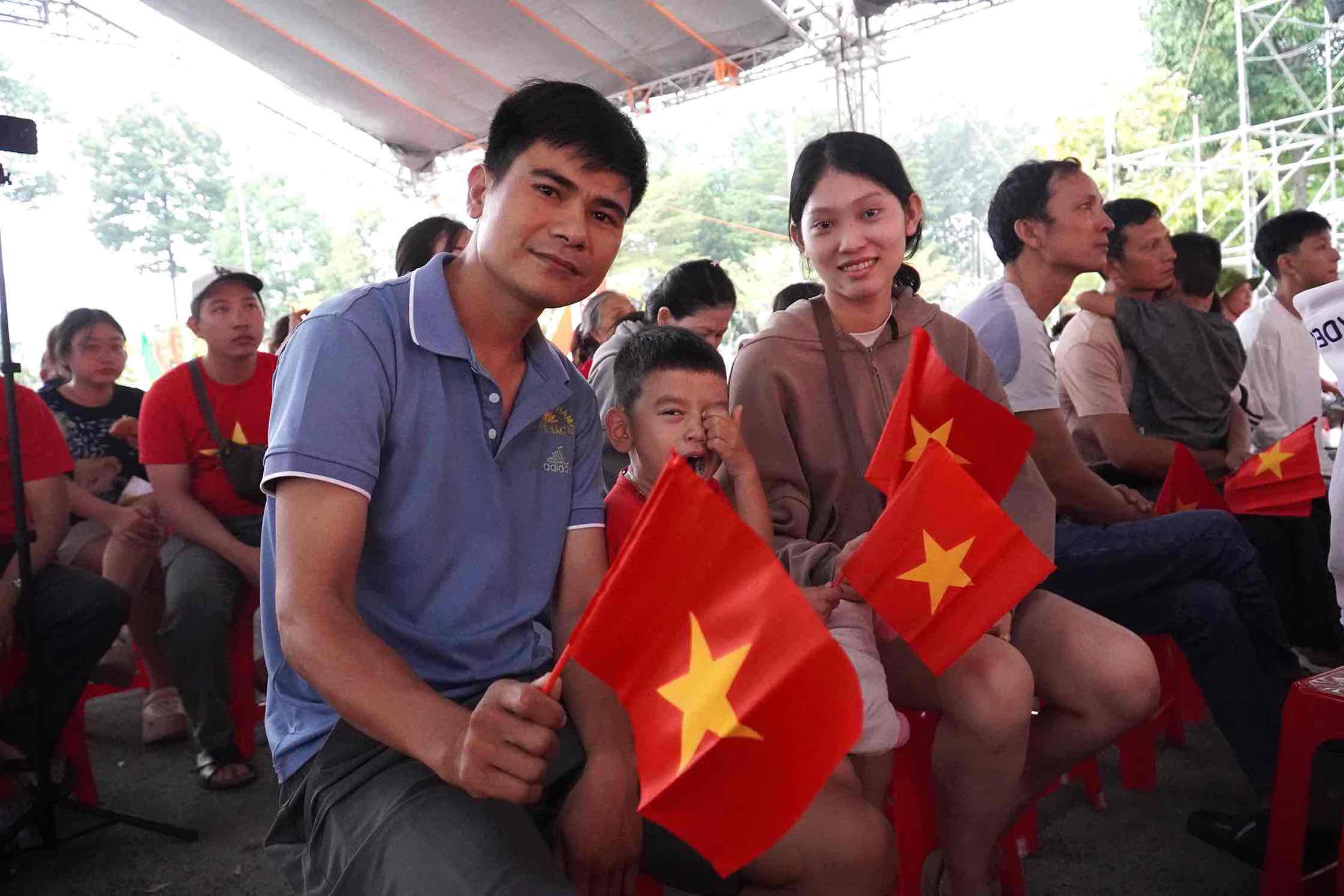 노동자 레 반 히에우 씨 가족은 아내와 자녀를 데리고 행진하는 브라 퍼레이드 생중계를 보기 위해 아침 일찍 일어났습니다. 사진: HAC