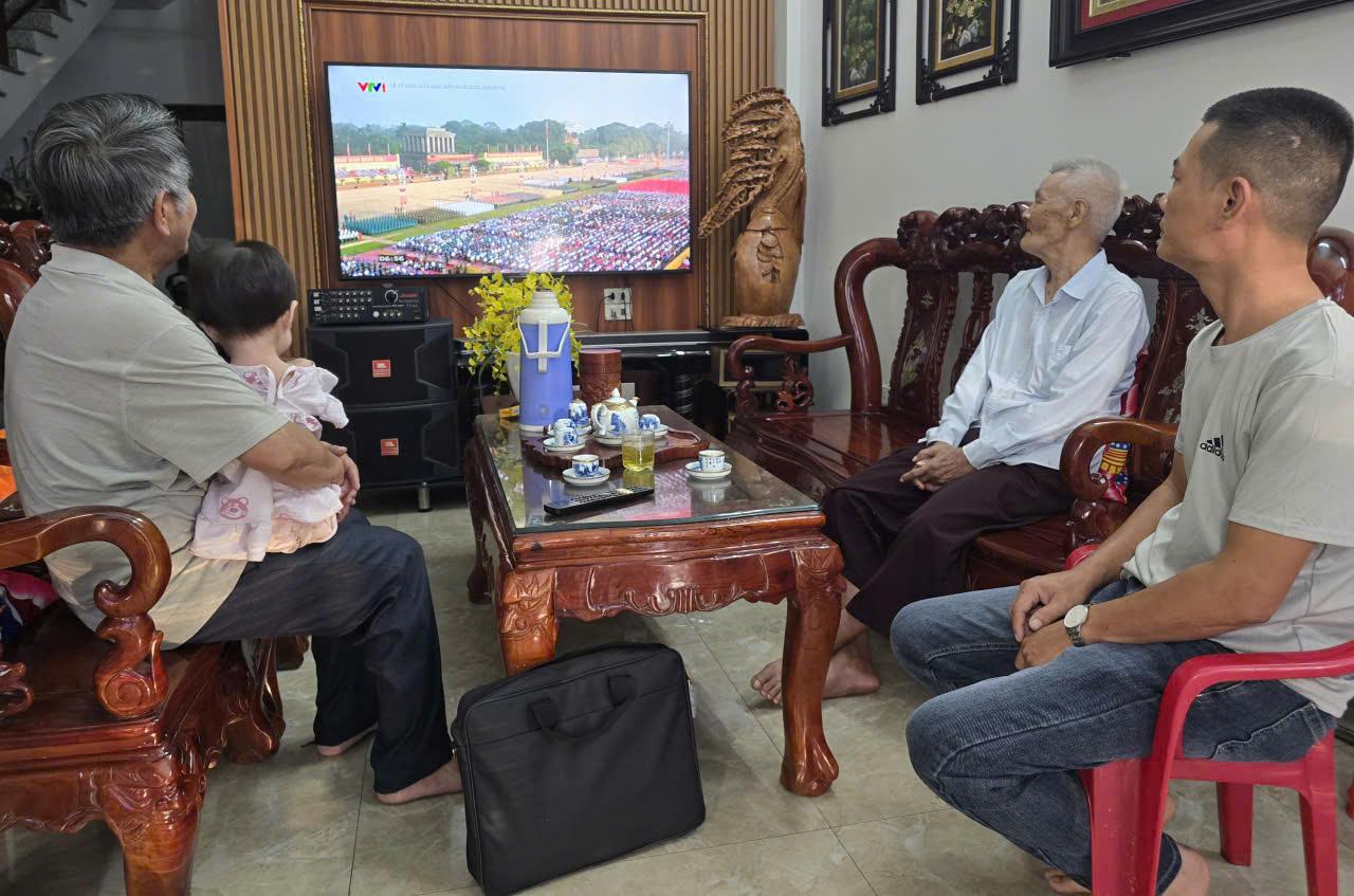 Gia dinh ong Ta Minh Hoang (pho Bac Thanh, phuong Hoa Lu) quay quan ben man hinh tivi de theo doi le dieu binh, dieu hanh. Anh: Dieu Anh