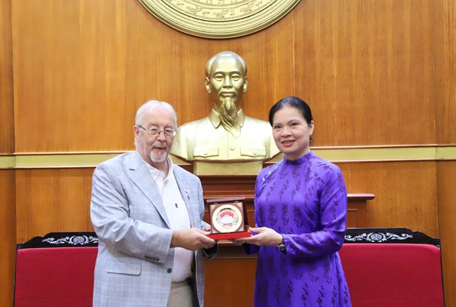 La Sra. Ha Thi Nga - Miembro del Comite Central del Partido Vicepresidenta del Comite Central del Frente de la Patria de Vietnam entrega recuerdos al Secretario del Partido Comunista Britanico Robert Griffiths. Foto: Minh Hien