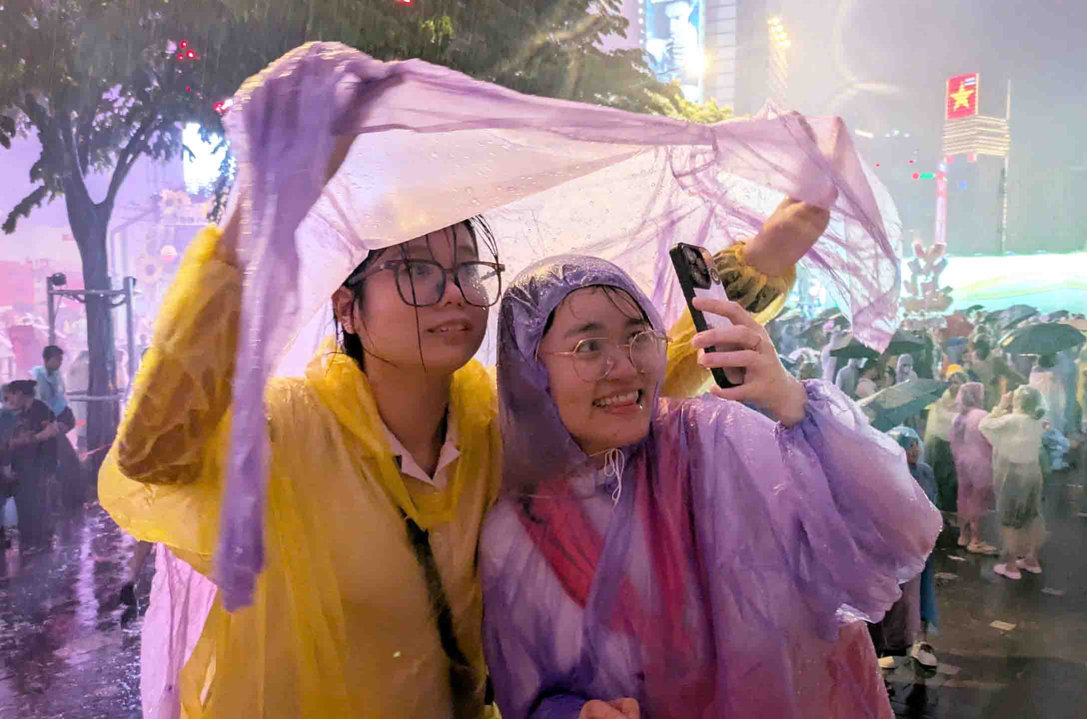 Nguoi dan tai trung tam TPHCM phai mac ao mua xem phao hoa. Anh: Viet Anh