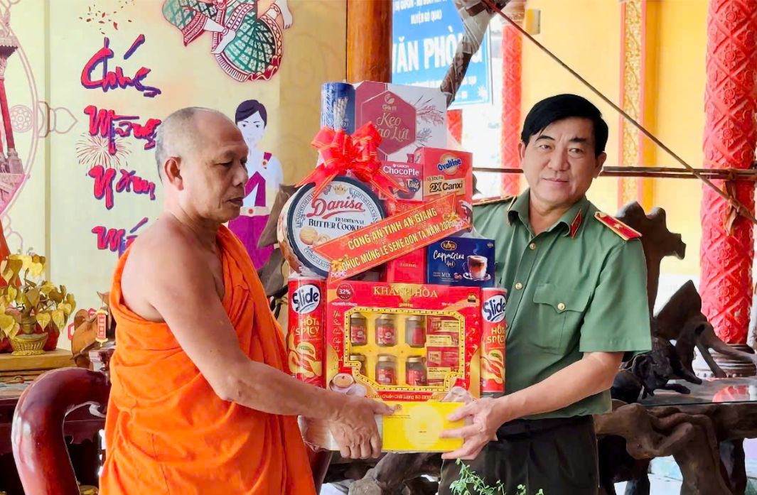 Thieu tuong Nguyen Van Han - Uy vien Ban thuong vu Tinh uy, Giam doc Cong an tinh tang qua cho Hoa thuong Danh Dong - Chu tich Hoi Doan ket su sai yeu nuoc tinh. Anh: Vu Tien 
