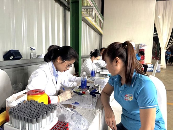 Union members and workers receive free health check-ups. Photo: Bao Trung