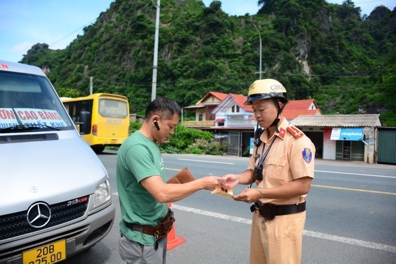 성 공안 교통 경찰이 랑선성 찌랑현을 통과하는 국도 1호선 구간에서 버스 운전자를 행정 검사하고 있습니다. 사진: Hoang Cuong