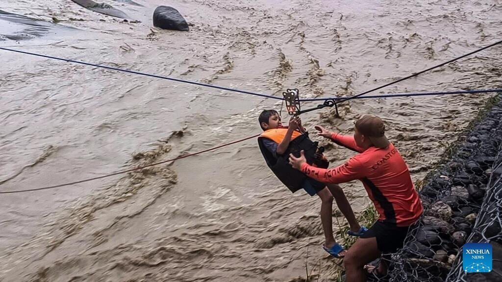 Rescue workers from the Philippine Coast Guard conduct a rescue using a rope on a fast-flowing river in Ilocos Sur province, Philippines, on September 22, 2025. Photo: Xinhua