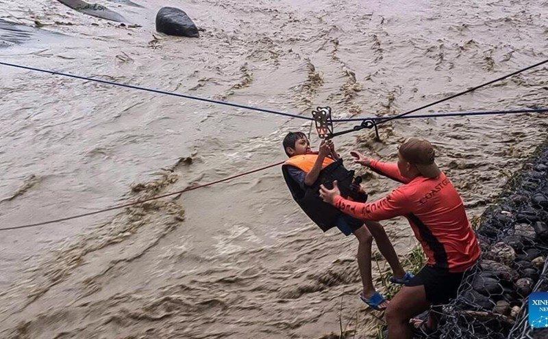 Rescue workers from the Philippine Coast Guard conduct a rescue using a rope on a fast-flowing river in Ilocos Sur province, Philippines, on September 22, 2025. Photo: Xinhua