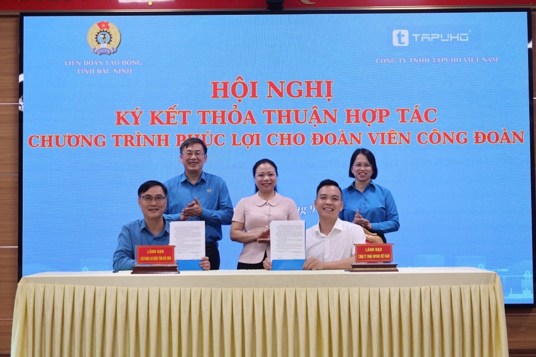 Lanh dao Lien doan Lao dong tinh va dai dien lanh dao Cong ty trach nhiem huu han Tapuho ky ket thoa thuan hop tac. Anh: Quyet Chien 