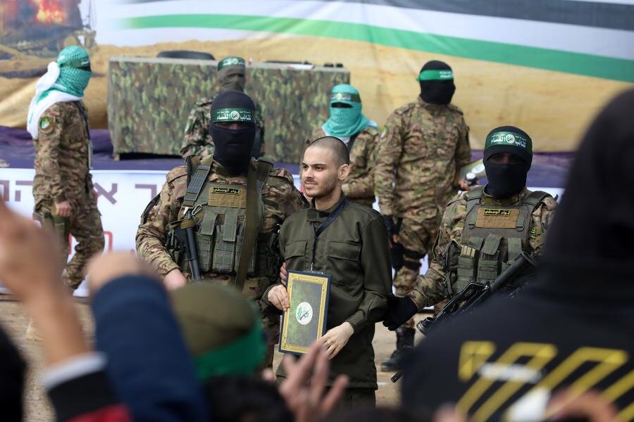 Thanh vien Hamas cung mot con tin Israel trong qua trinh ban giao cho Uy ban Chu thap do Quoc te tai trai ti tai Gaza, ngay 22.2.2025. Anh: Xinhua