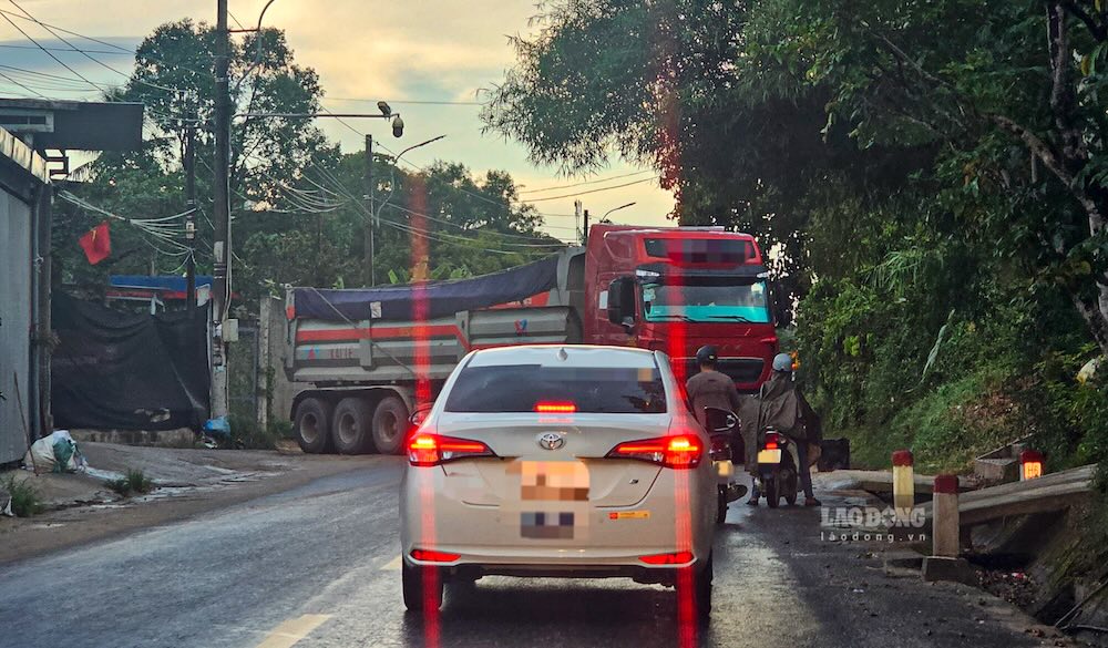 Các phương tiện tham gia giao thông thời điểm này phải dừng lại, chờ chiếc xe lớn lùi vào bãi ngay cạnh đường. Ảnh: PV