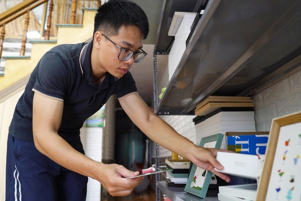 Anh Hua Duy Thanh dang sap xep cac buc tranh lam tu thuy tinh vo. Anh: Doan Hung