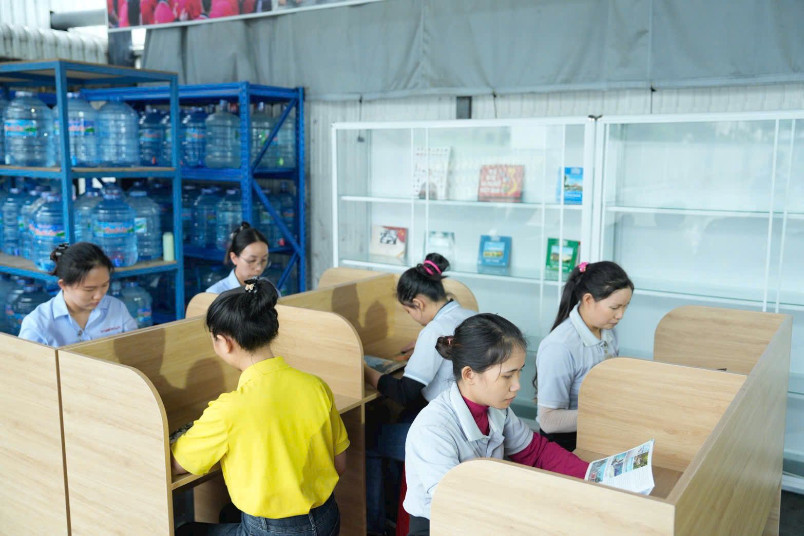 Nguoi lao dong doc sach bao trong gio nghi giua ca. Anh: Dinh Trong