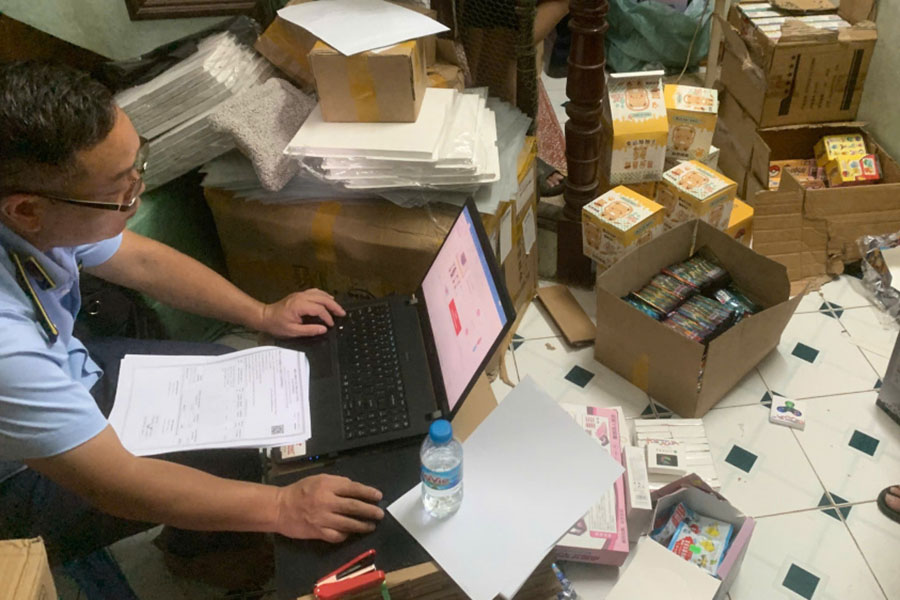 QLTT 병력이 밀수 의혹이 있는 아동용 장난감 상품을 검사하고 있습니다. 사진: 하노이 QLTT 지국