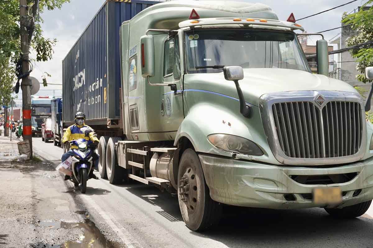 Xe tai, container xep hang dai, di chuyen tren duong Nguyen Duy Trinh de thoat qua truoc khung gio cam. Anh: Nhu Quynh