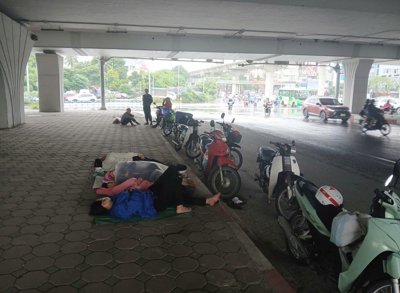 Nguoi lao dong ngu trua duoi gam cau tren duong Pham Hung (TP Ha Noi). Anh: Thanh Nhan