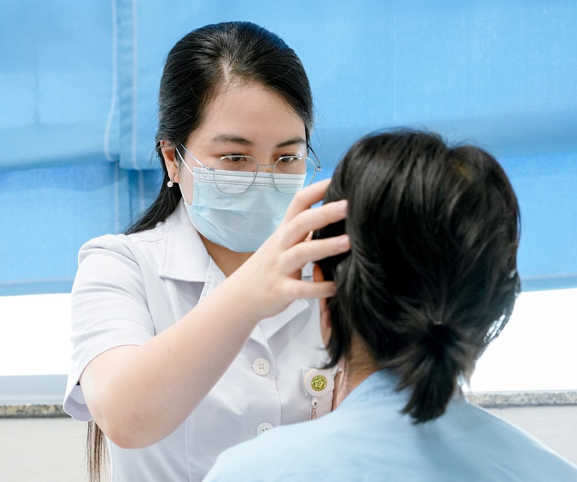 Doctor Tran Thi Quyen examines a patient with severe irritated contact dermatitis, secondary infection due to complications after exfoliation. Photo: Thanh Duong