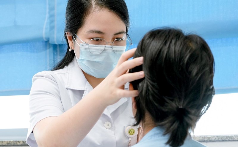 Doctor Tran Thi Quyen examines a patient with severe irritated contact dermatitis, secondary infection due to complications after exfoliation. Photo: Thanh Duong