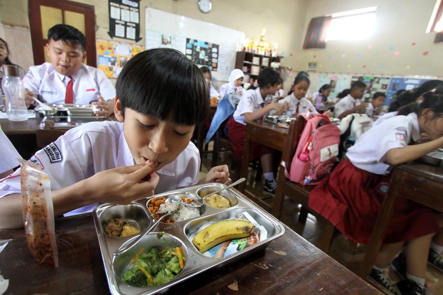 Indonesian students eat free lunch. Photo: Xinhua