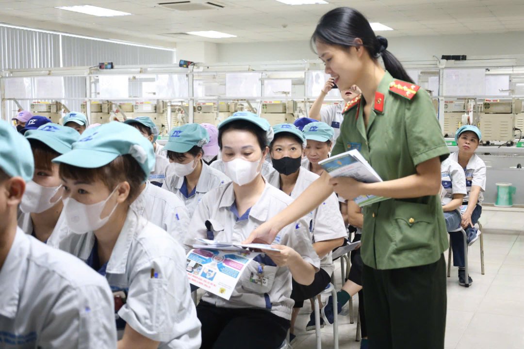 Workers received leaflets to promote online fraud prevention at the conference. Photo: Quyet Chien