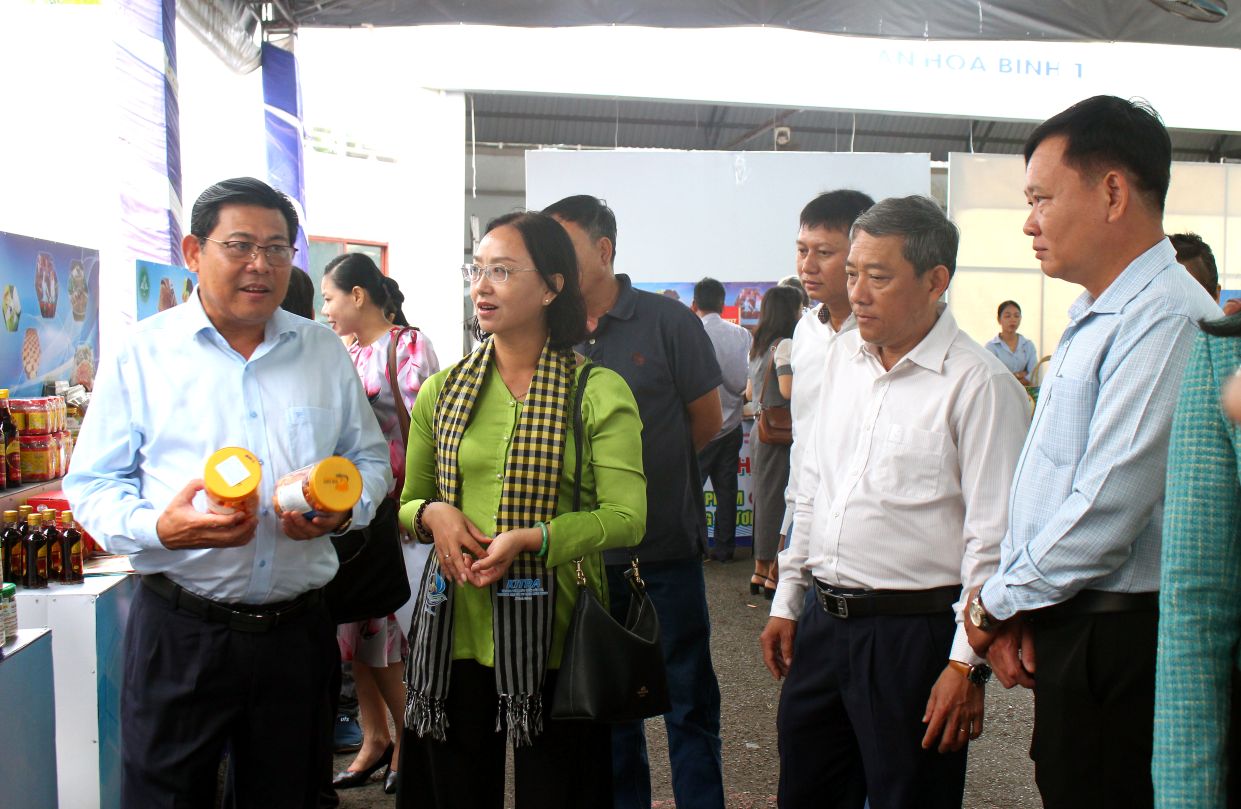 Pho Chu tich UBND tinh An Giang Ngo Cong Thuc (bia trai anh) tham quan cac gian hang OCOP trung bay tai hoi nghi. Anh: Thanh Mai