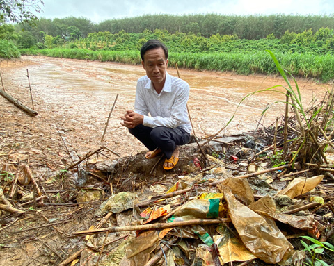 Mr. Truong was saddened by the polluted fish pond, next to which were garbage, bottles, and broken glass flowing from the Ngoc Hoi Waste Treatment Complex. Photo: Thanh Tuan