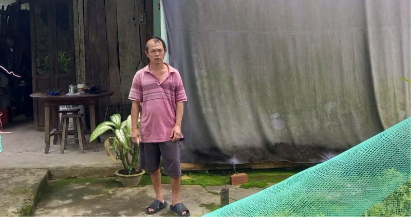Mr. Ngo Van Hung is struggling with a brain tumor in an empty house in front of the drum behind. Photo: Hoang Loc