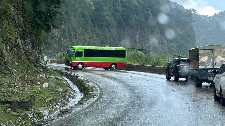 Xe Bus truot ngang tren doan cua Quoc lo 6 khi mat duong tron truot do mua lon. Anh: Dang Tinh