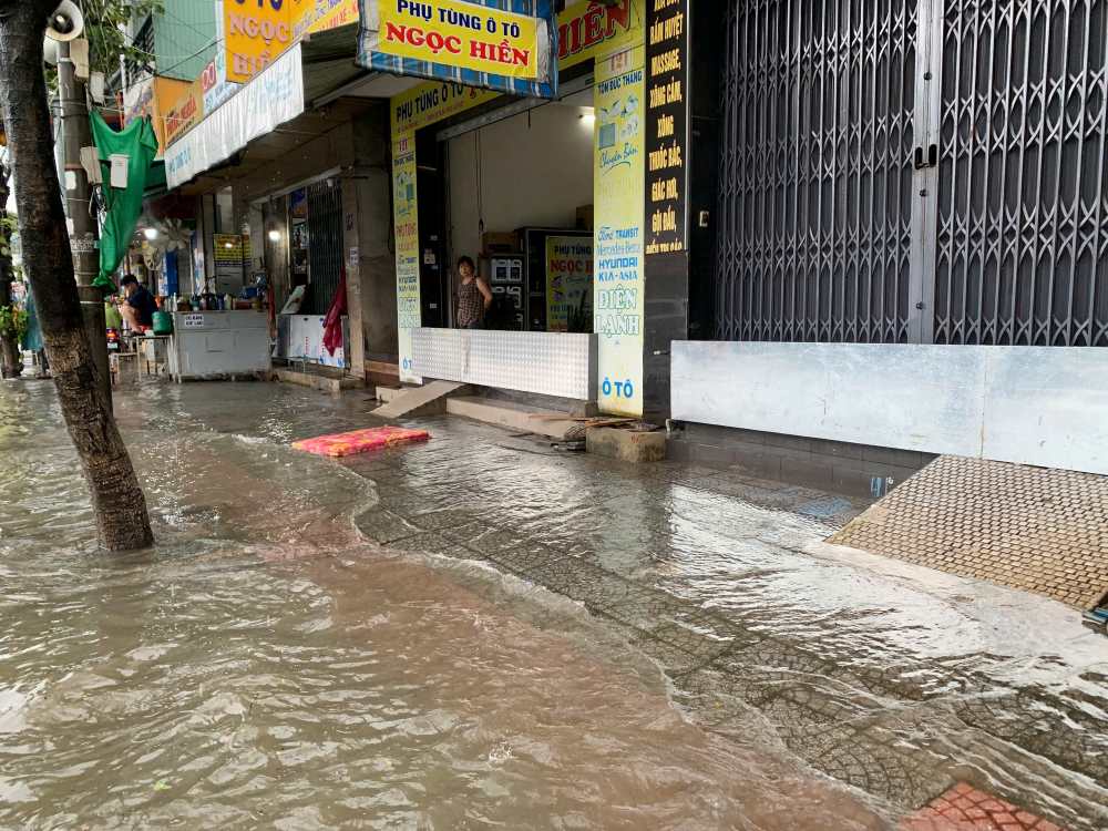 Arrives jusqu'a la porte les habitants de Da Nang utilisent un panneau de tole pour empecher l'eau de penetrer dans la maison. Photo : Thanh Huyen