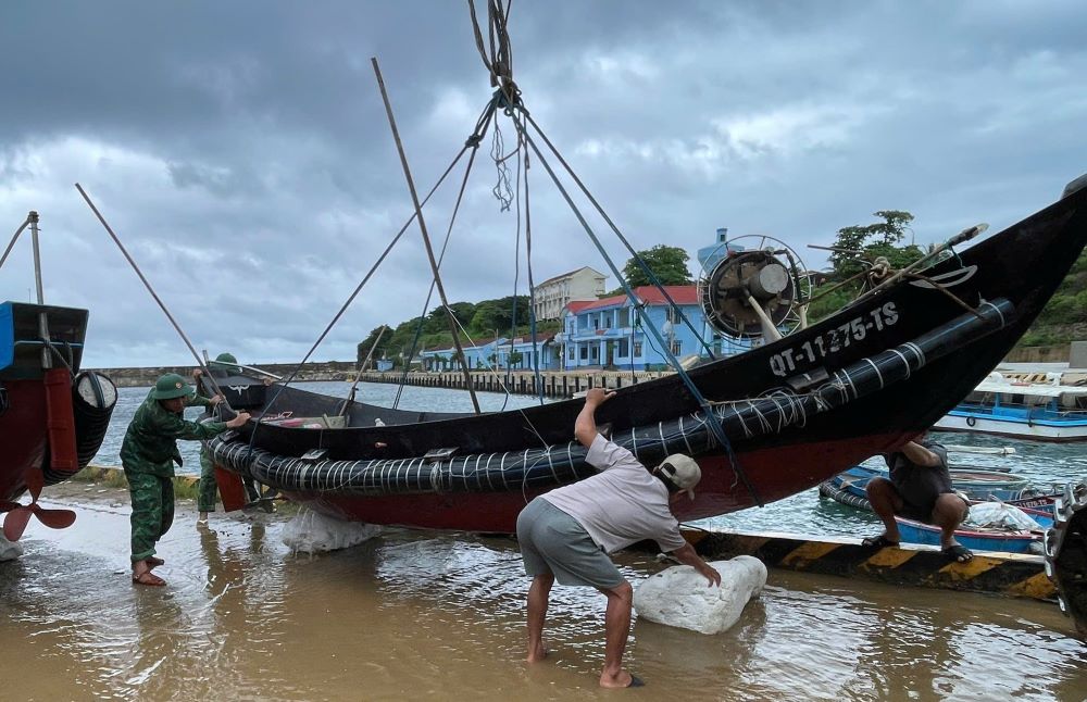 Les gardes-frontieres et les habitants amenent les bateaux a terre pour eviter la tempete n° 10. Photo : Les gardes-frontieres de Quang Tri