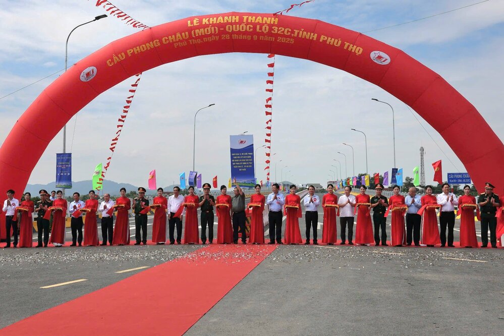 Prime Minister Pham Minh Chinh, General Phan Van Giang and leaders and delegates cut the ribbon to inaugurate the new Phong Chau bridge. Photo: Duc Hoang.