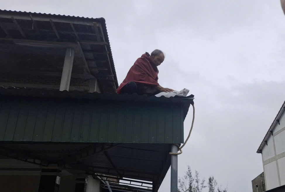 Mr. San, 75 years old, is reinforcing the roof to prevent storm No. 10. Photo: Tran Tuan.