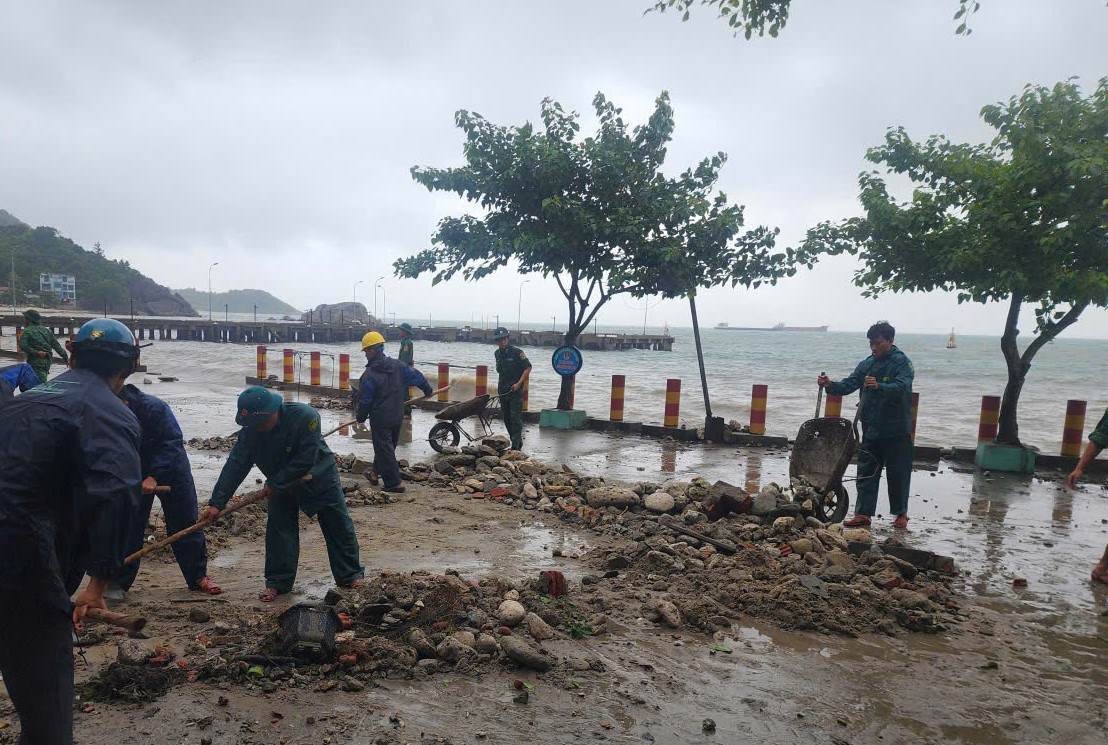 On the morning of September 28, soldiers and people of Tan Hiep island commune, Da Nang cleared the rocks and soil washed ashore by the waves. Photo: Le Moi