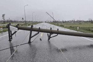 A series of power poles in Ha Tinh were broken by storm No. 10 and swept out onto the road. Photo: Tran Tuan
