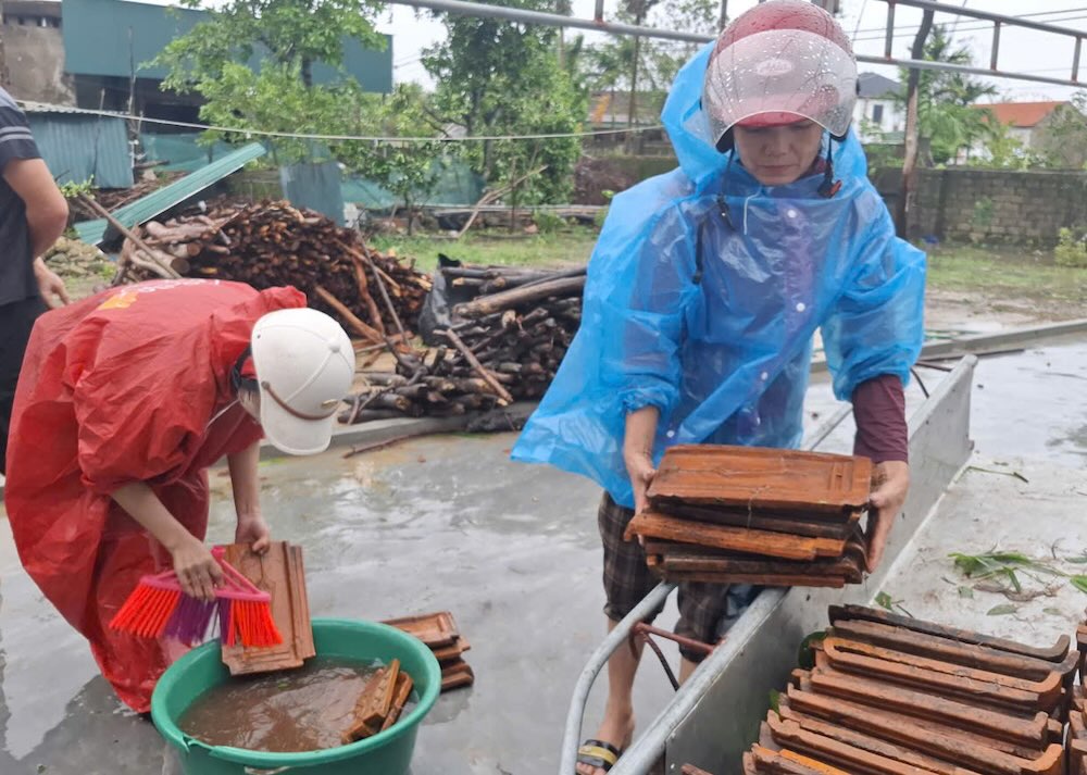 Ba Quyet (ao xanh) cung ca nha lop lai mai ngoi sau khi bao so 10 tan pha. Anh: Tran Tuan