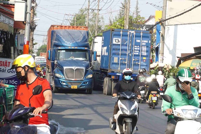 Container trucks occupy the entire Nguyen Duy Trinh lane (HCMC). Photo: Minh Quan